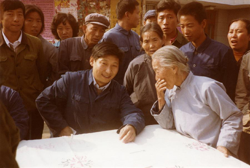 1983年，時(shí)任河北正定縣委書記的習(xí)近平（前排居中），臨時(shí)在大街上擺桌子聽取老百姓意見。